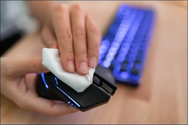 wiping a mouse to clean it